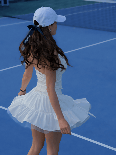 White ruffle tennis skirt with bow details, a soft layered look and airy movement.
