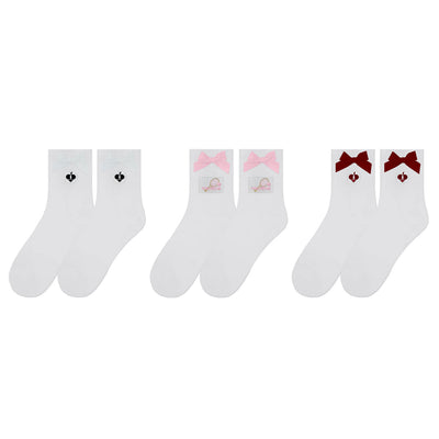 White ankle tennis socks with red bow detail and Pom Pêche logo, styled on the court.