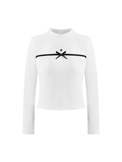 White long-sleeve top with a smooth silhouette and contrast bow detail, styled on the tennis court.