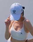Person wearing a white cap and sports bra with visible branding against a light background