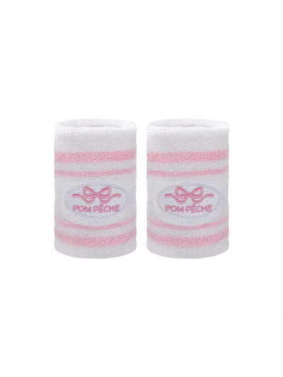 White tennis wristbands with soft pink stripes, featuring embroidered bow and logo details.