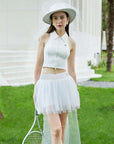 White puff tulle tennis skirt paired with sleeveless top, highlighting soft mesh layers and a high-waisted tennis skirt fit on garden court.