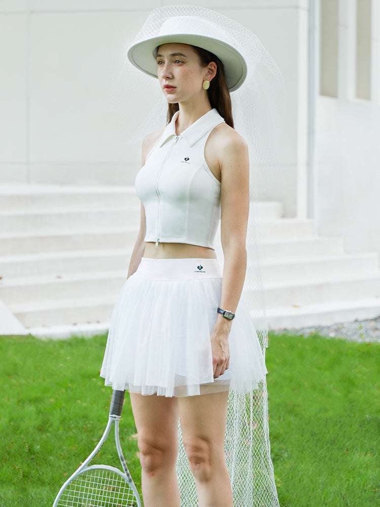 White tulle puff tennis skirt worn with structured top, highlighting soft mesh layers and a refined high-waisted athletic tennis skirt look.