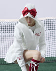 White zip-up hoodie with bow detail on the hood and embroidered logo, perfect for warm-ups or everyday wear.
