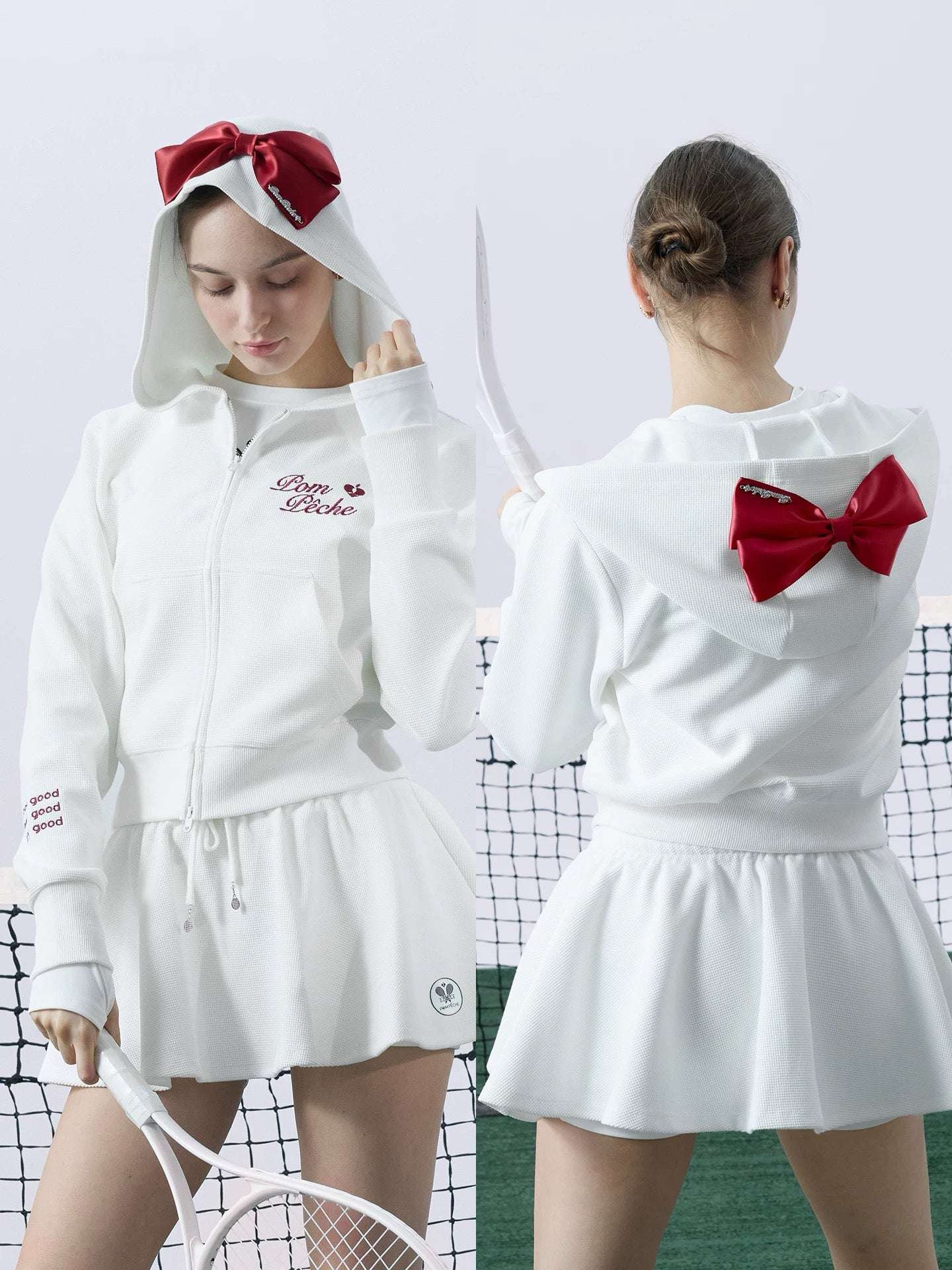 White zip-up hoodie with bow detail on the hood and embroidered logo, perfect for warm-ups or everyday wear.