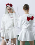 White zip-up hoodie with bow detail on the hood and embroidered logo, perfect for warm-ups or everyday wear.