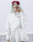 White zip-up hoodie with bow detail on the hood and embroidered logo, perfect for warm-ups or everyday wear.