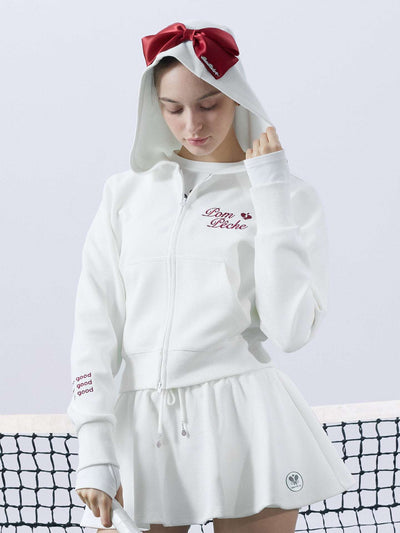 White zip-up hoodie with bow detail on the hood and embroidered logo, perfect for warm-ups or everyday wear.