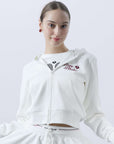 White zip-up hoodie with bow detail on the hood and embroidered logo, perfect for warm-ups or everyday wear.