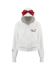 White zip-up hoodie with bow detail on the hood and embroidered logo, perfect for warm-ups or everyday wear.