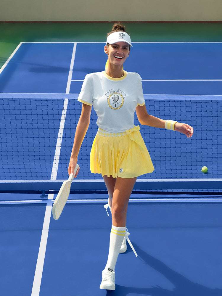 Yellow and white cropped graphic tennis tee with a printed design, offering a lightweight, breathable feel for warm-weather play.