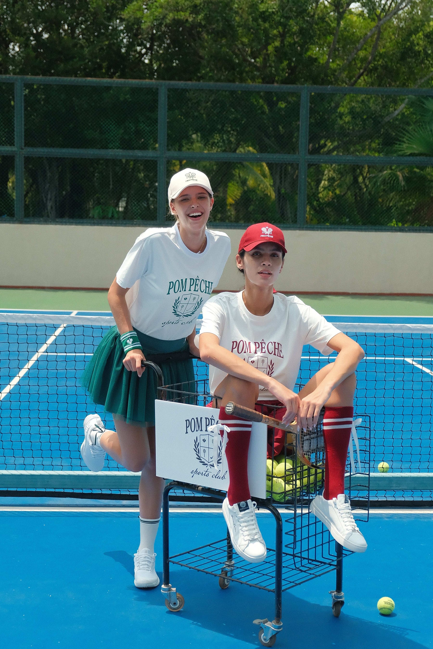 White graphic tee with a green bold Pom Pêche logo, offering a relaxed fit for ultimate comfort and style.