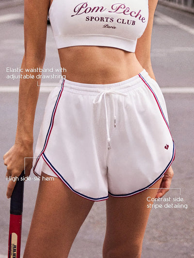 White side-slit active shorts with elastic drawstring waistband, high side-slit hem, and contrast side stripe detailing