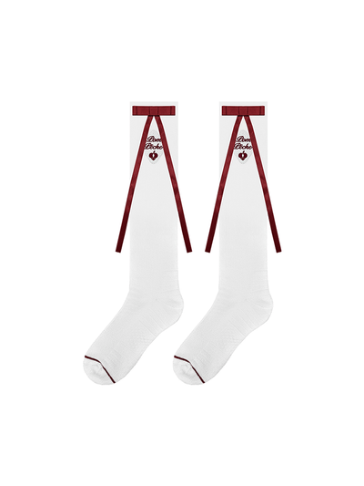 White knee-high tennis socks with red bow detail and logo embroidery.