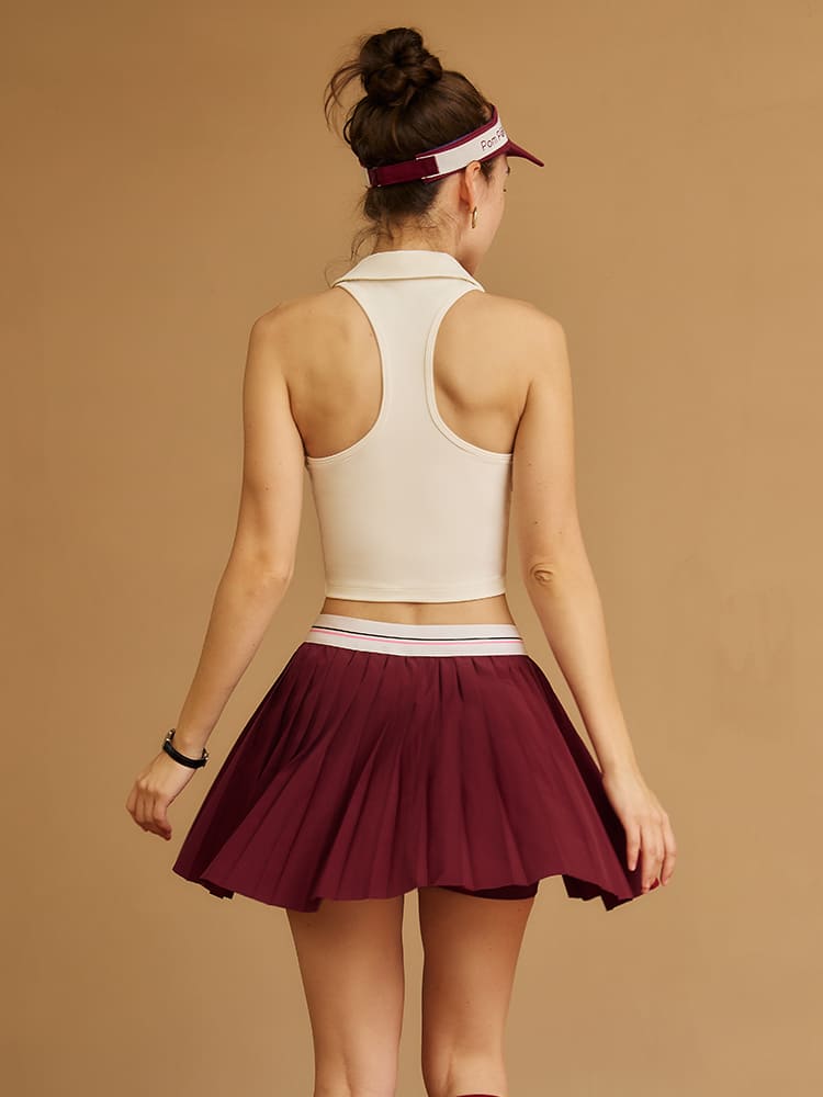 pleated athletic skirt in wine red shown from back view emphasizing flowy silhouette and high-waisted fit
