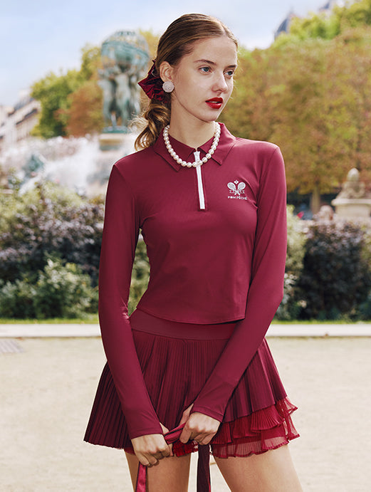 Deep red long-sleeve zip-collar polo top with a subtle printed logo, featuring a fitted silhouette for a sleek, sporty look.