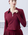 Deep red long-sleeve zip-collar polo top with a subtle printed logo, featuring a fitted silhouette for a sleek, sporty look.