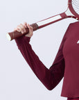 Deep red long-sleeve zip-collar polo top with a subtle printed logo, featuring a fitted silhouette for a sleek, sporty look.