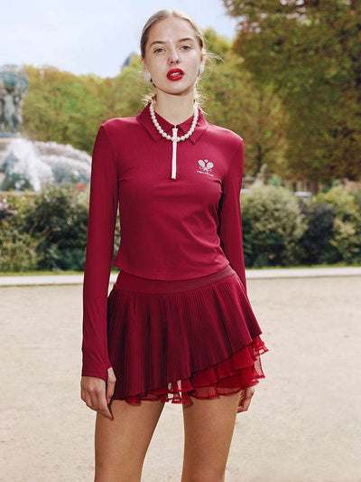 Burgundy pleated tennis skirt with layered mesh detail styled outdoors