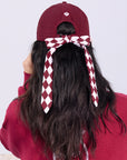 Wine red tennis cap with embroidered logo and adjustable ribbon on the back strap.