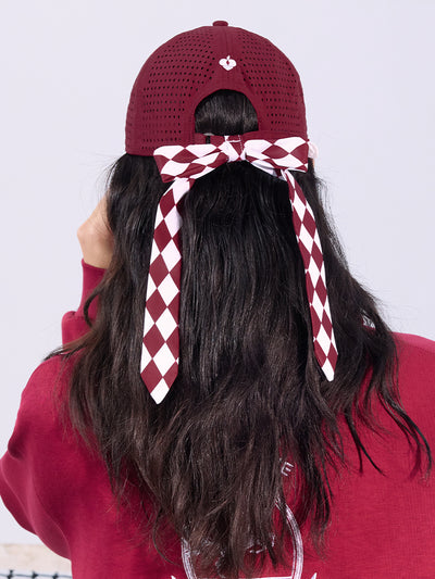 Wine red tennis cap with embroidered logo and adjustable ribbon on the back strap.