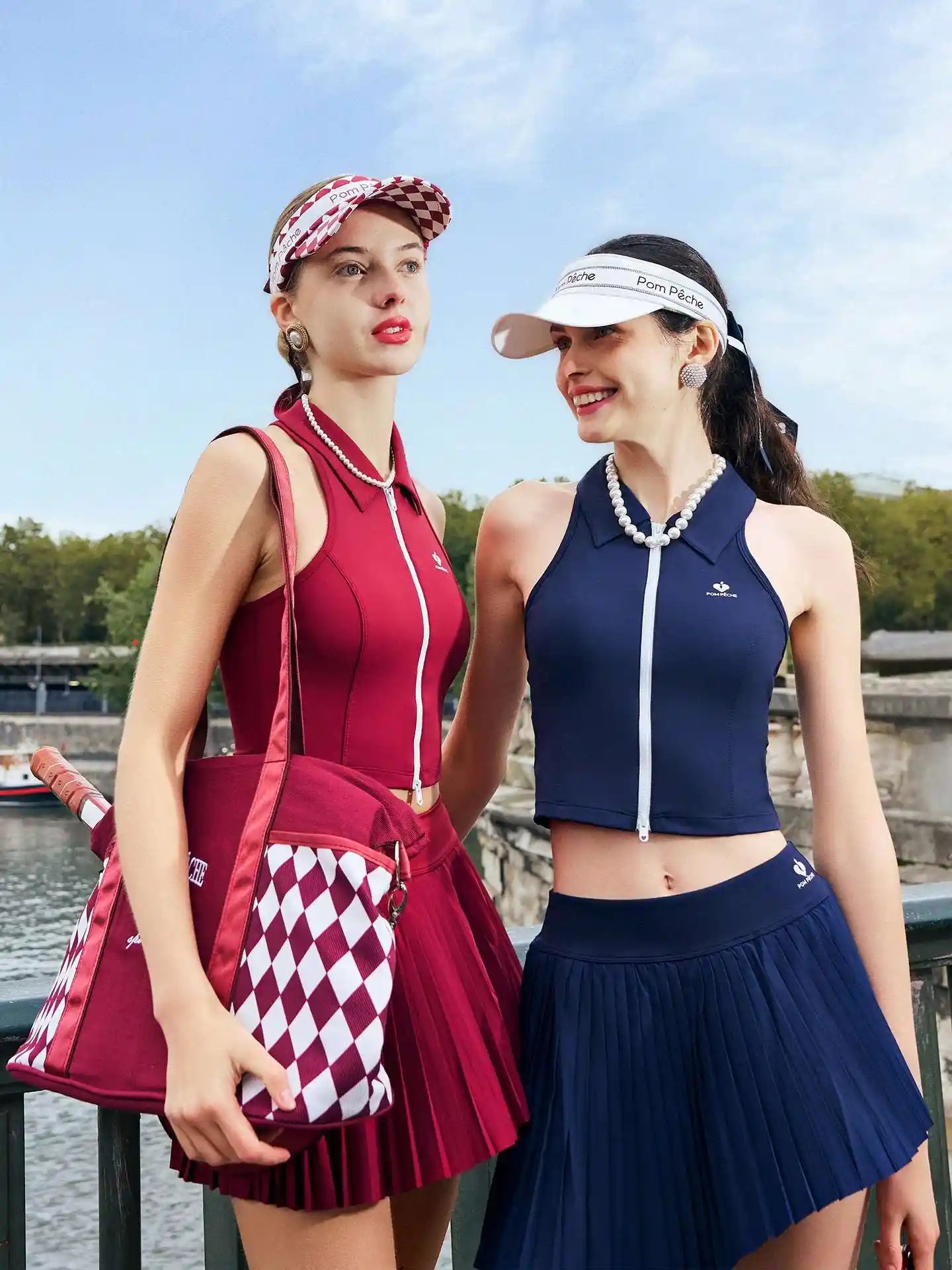 Two women in matching outfits with visors and skirts standing outdoors.