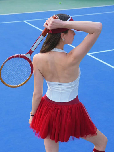 Wine red puff tulle tennis skirt styled with white halter top, highlighting floating mesh layers and high-waisted tennis skirt silhouette.