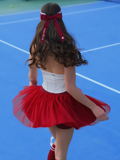 Back view of wine red puff tulle tennis skirt in motion, emphasizing airy volume and high-waisted tennis skirt design on court.