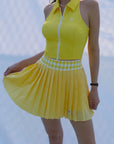 Person wearing a yellow dress with a white checkered pattern on a blurred background