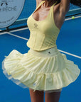 Person wearing a yellow tennis outfit on a tennis court