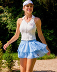 Betty Boop Cake Skirt Paris Blue styled with a tennis outfit, showcasing a feminine sporty look, tiered ruffle mesh design, and elegant activewear style