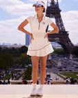 Betty Boop Poise™ V-Neck Polo Top white, full body editorial shot at Eiffel Tower Paris, white tennis set with visor and sneakers