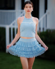 Blue Bow Halter Tennis Top worn with matching blue ruffle tennis skirt, Pom Pêche court-to-street full outfit