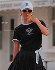 Contrast Trim Tennis Tee black UPF 50+ callout, Pom Pêche Paris racquet logo on chest, white contrast trim collar, slim 3D fit