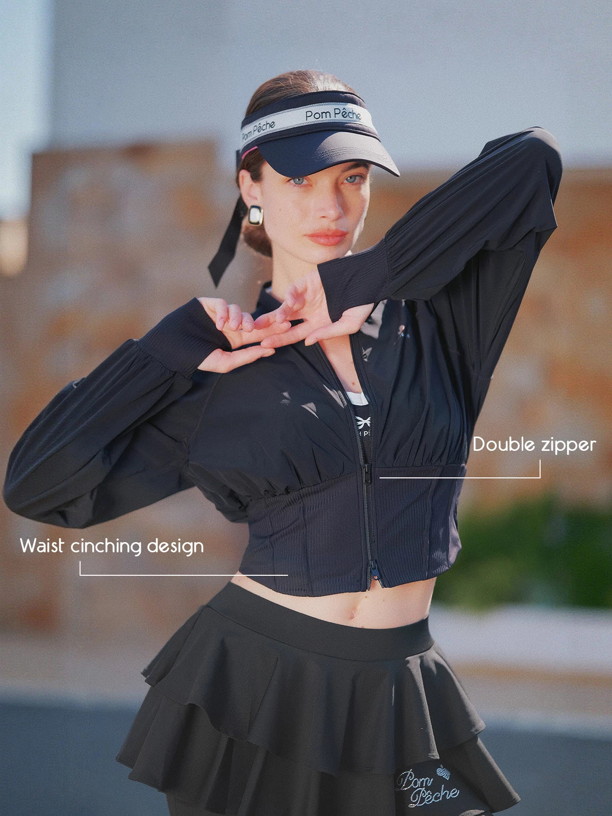 Cropped UV tennis jacket in black with dual zipper and waist cinch design, women’s fitted sporty jacket front view