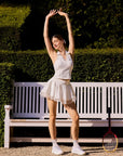 La Rose Collared V Neck Top styled in a tennis lifestyle scene, showcasing elegant sporty outfit, sculpting fit, deep V neckline, and versatile women's activewear look