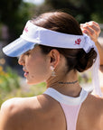 La Rose Ruffle Performance Visor White styled with activewear, showcasing feminine French elegance and modern sporty performance