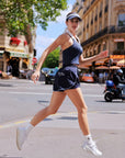 Navy active shorts side view while running, high side slit and contrast stripe