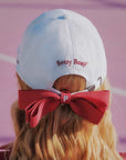 White cap with red bow and 'Betty Boop' logo on a blurred background