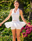 Poise Rose Halter Polo Tank White styled with women's tennis outfit, combining romantic rose details, sporty performance, and court-to-café versatility