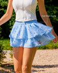 Pom Pêche x Betty Boop Paris blue Cake Skirt feature callout – High Waist A-Line silhouette and Double-Layer Polka Dot Mesh annotated, Betty Boop Pom Pêche circular badge on lower tier, styled with white zip halter top in garden