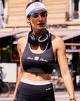 Close-up of Pom Pêche x Betty Boop black tank top with feature callouts – built-in padded bra, Betty Boop collab logo print and UPF 50+ cooling performance fabric