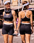 Pom Pêche x Betty Boop black mesh back tank top – front and back view showing racerback silhouette and Betty Boop logo, styled with matching black shorts on Paris street
