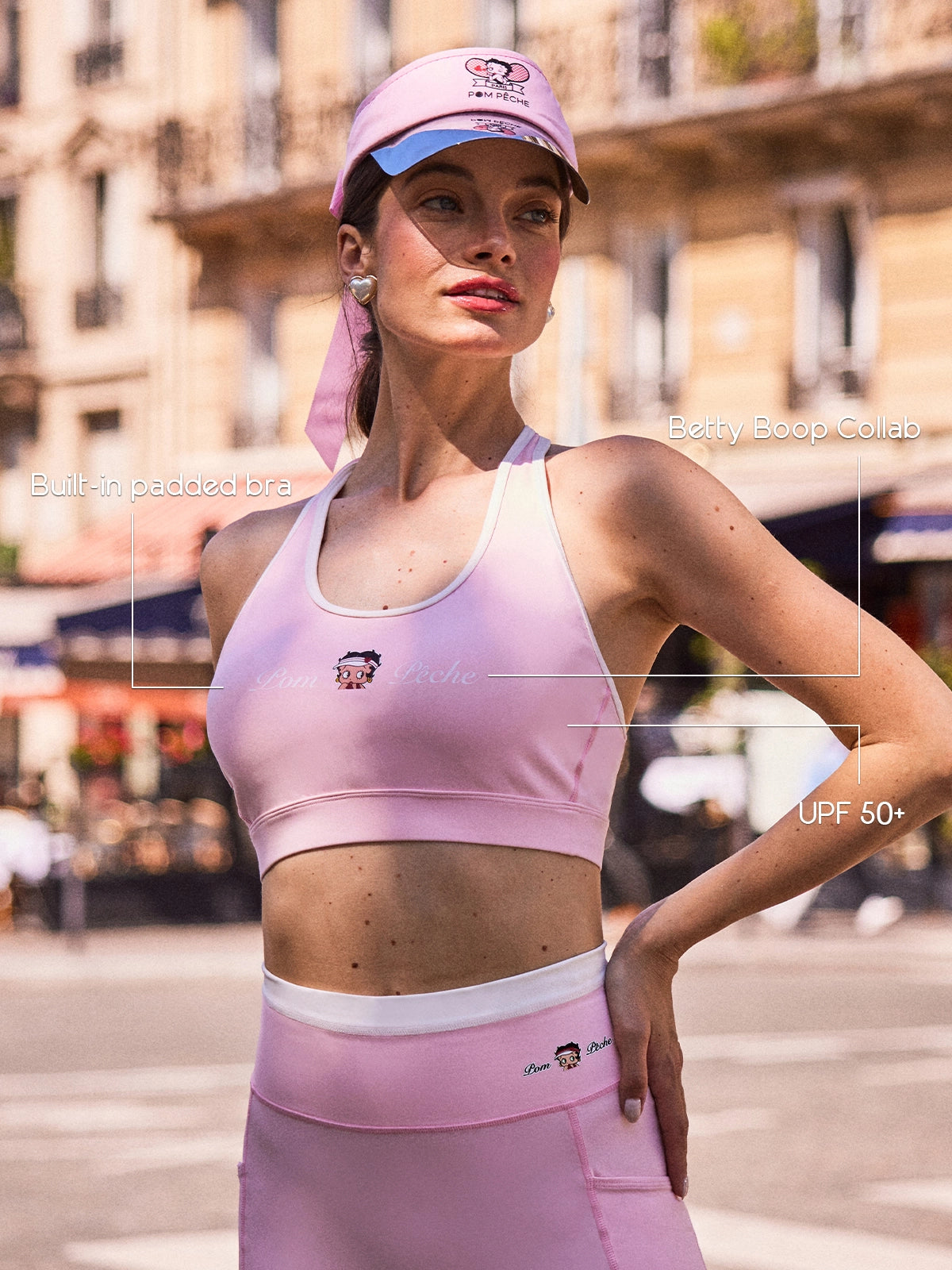 Close-up of Pom Pêche x Betty Boop pink tank top with feature callouts – built-in padded bra, Betty Boop collab logo print and UPF 50+ cooling LYCRA® performance fabric annotated