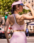 Back view of Pom Pêche x Betty Boop pink tank top with Mesh Racerback Design callout – breathable open racerback with white contrast trim, worn with Pom Pêche visor on Paris street