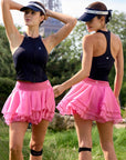 Pom Pêche black zip-neck halter racerback tank – front and back view styled with pink ruffle tennis skirt near Eiffel Tower, paired with Pom Pêche visor