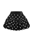 Flat lay of Pom Pêche Bubble A-Line Tennis Skirt in black – high-waisted band with Pom Pêche logo, voluminous bubble hem with white heart and logo allover print on white background