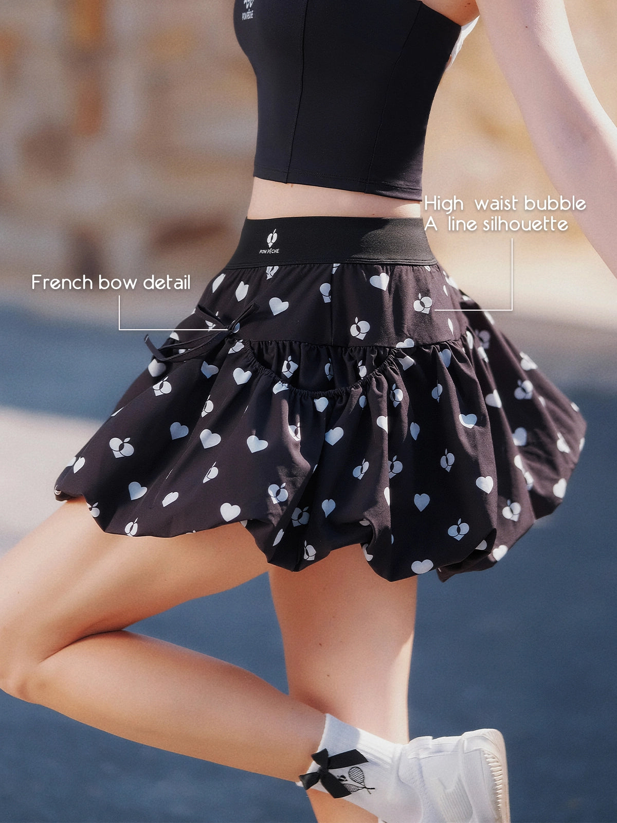 Pom Pêche black Bubble A-Line Skirt feature callout – French bow detail at waist and high-waist bubble A-line silhouette for sculpted waist and balanced hip ratio, heart logo print