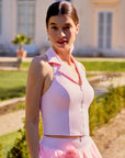 Side view of Pom Pêche pink halter polo tank with built-in bra support, polo collar and front zip, worn at a French estate – women's tennis top with UPF 50+ protection