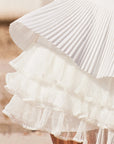 Macro detail of Pom Pêche Spin™ LaRose skirt showing three-layer irregular pleated mesh inner structure – lightweight woven outer layer over airy tiered mesh for elegant volume